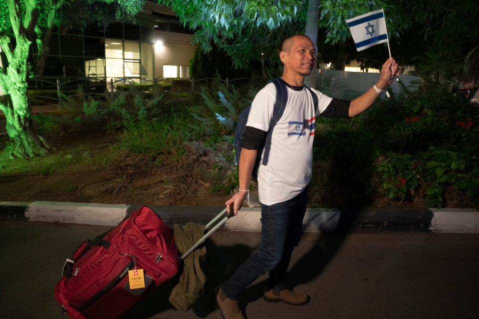 A Thai national waves an Israeli flag while walking to a bus leaving the Shamir Hospital in Ramle, Israel, Wednesday, 29 November 2023, on his way back to Thailand, after being released from Hamas custody. International mediators on Wednesday worked to extend the truce in Gaza, encouraging Hamas militants to keep freeing hostages in exchange for the release of Palestinian prisoners and further relief from Israel's air and ground offensive (Copyright 2023 The Associated Press All rights reserved)