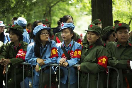 People wear communist era uniform costumes as they wait to meet Chinese millionaire Chen Guangbiao during a lunch he sponsored for hundreds of needy New Yorkers at Loeb Boathouse in New York's Central Park June 25, 2014. REUTERS/Lucas Jackson