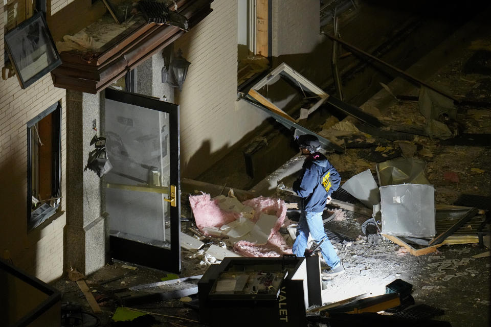 An official surveys an area near the back entrance to the Sandman Signature hotel following an explosion, Monday, Jan. 8, 2024, in Fort Worth, Texas. (AP Photo/Julio Cortez)