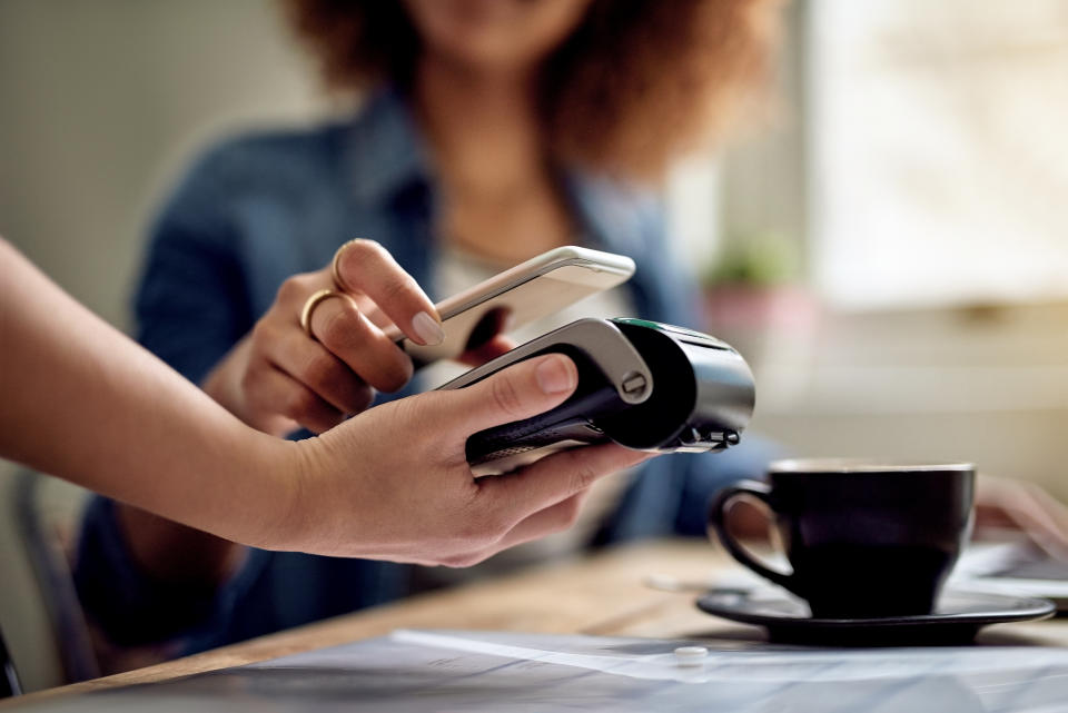 Woman paying for a bill with an eftpos machine