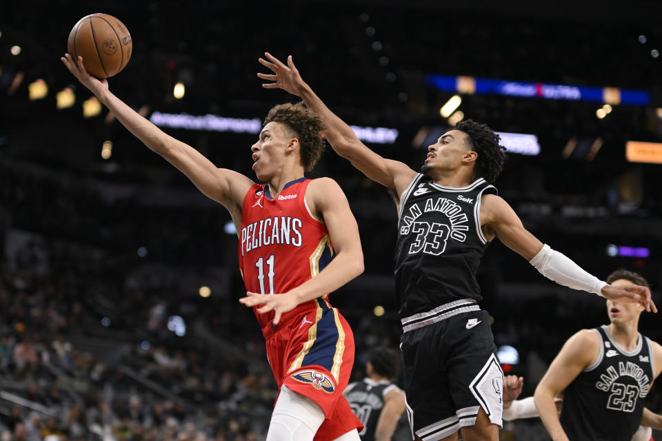 New Orleans Pelicans' Dyson Daniels (11) drives to the basket past San Antonio Spurs' Tre Jones during the second half of an NBA basketball game, Friday, Dec. 2, 2022, in San Antonio. (AP Photo/Darren Abate)