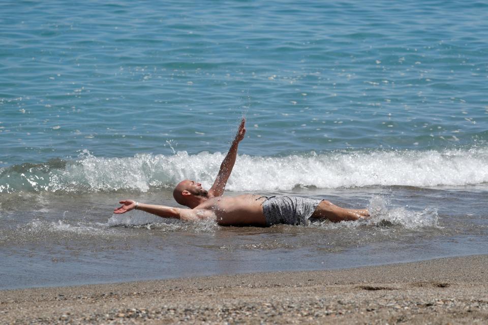 A man cools off in the Mediterranean Sea near La Malagueta beach, as some Spanish provinces are allowed to ease lockdown restrictions (REUTERS)