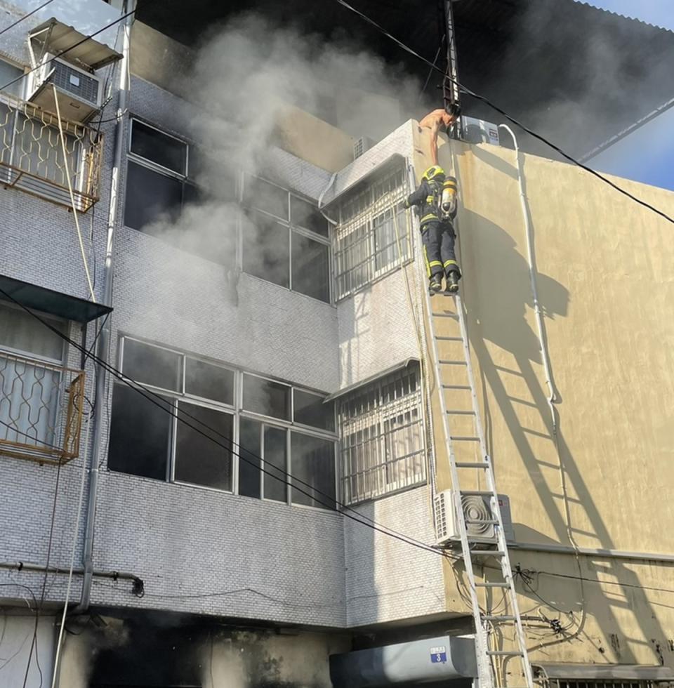 
台中市東勢區21日發生民宅火警，民眾逃到4樓頂樓，
消防人員架梯搶救。
（民眾提供）