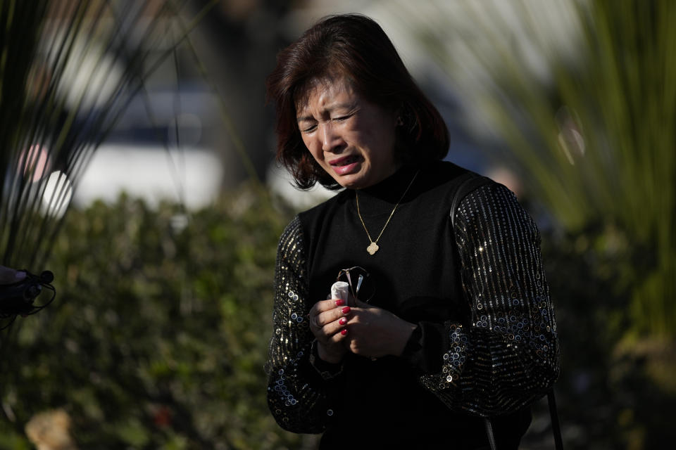 Judy Man is emotional near a memorial outside Monterey Park City Hall, blocks from the Star Ballroom Dance Studio on Tuesday, Jan. 24, 2023, in Monterey Park, Calif. A gunman killed multiple people at the ballroom dance studio late Saturday amid Lunar New Years celebrations in the predominantly Asian American community. Man was a student at the dance studio but was not present at the shooting. (AP Photo/Ashley Landis)