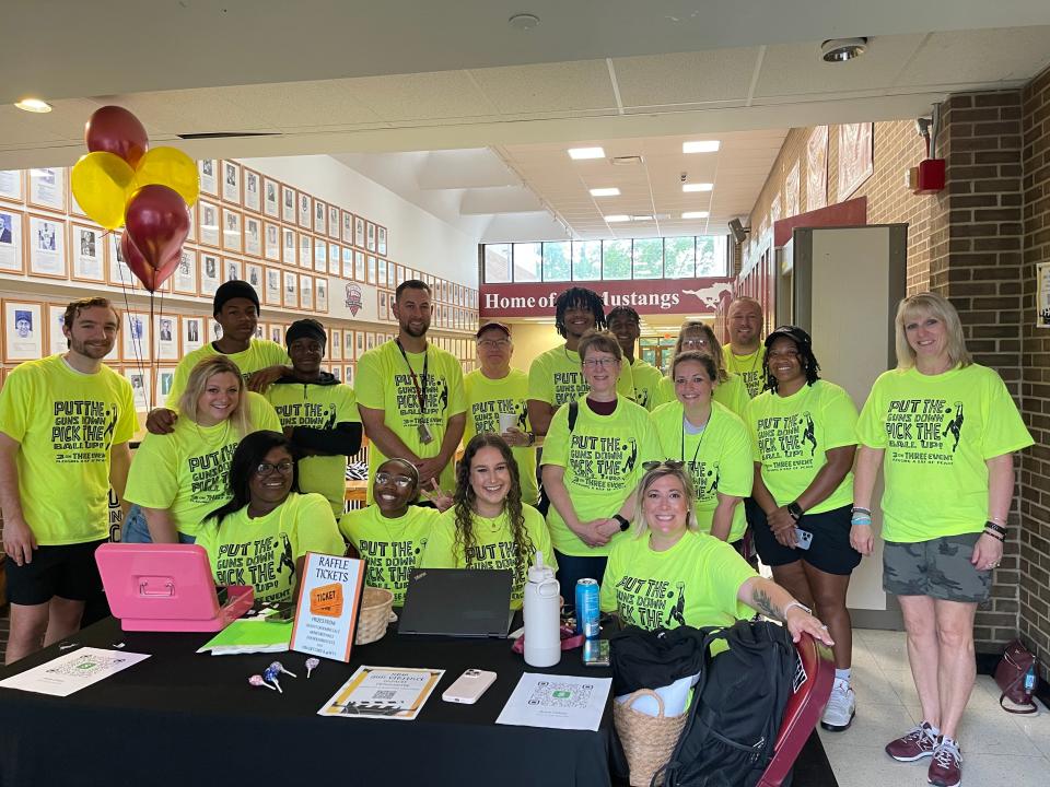 Kids and teachers from Western Hills University High School put on a basketball fundraiser Saturday to address youth gun violence. Anna Colyer (far right, first row), intervention specialist at West High, and Victoria Oakley (far left, second row), a social worker at the school, are pictured.