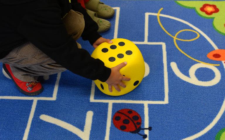 A preschool child plays a game at a kindergarten in Eichenau, near Munich, southern Germany, on October 9, 2013