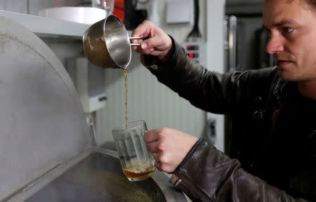 Vit Spacil, co-owner of the "Smart Brewery", pours beer to be sampled in a portable brewery built in a standard shipping container, in Prague, Czech Republic, September 2, 2017. Picture taken September 2, 2017. REUTERS/David W Cerny