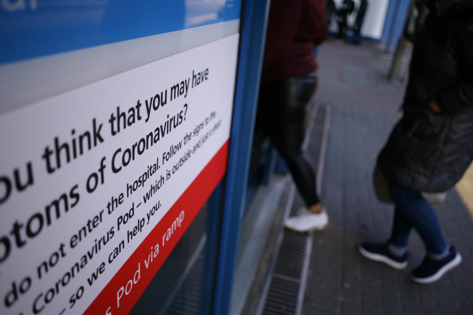 A sign directing people with symptoms of the covid-19 coronavirus to a 'coronavirus pod' isolation unit covers a window of an entrance to St Mary's Hospital in London, England, on March 11, 2020. In the UK, 460 people have now been confirmed to have the virus. Six patients with coronavirus have so far died in hospitals around the country. 