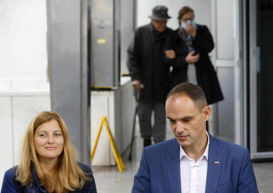 Right-wing former foreign minister and candidate for president, Anze Logar, right, and his partner Anja Rustja wait at a polling station in Ljubljana, Slovenia, Sunday, Oct. 23, 2022. Voters in Slovenia on Sunday cast ballots to elect a new president of the European Union nation, with three main contenders leading the race but no clear winner in sight. (AP Photo)