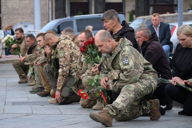 Ukrainian servicemen in Kyiv kneel Wednesday before the coffin of Oleksandr Pastukh during the funeral for the Armed Forces of Ukraine sergeant.