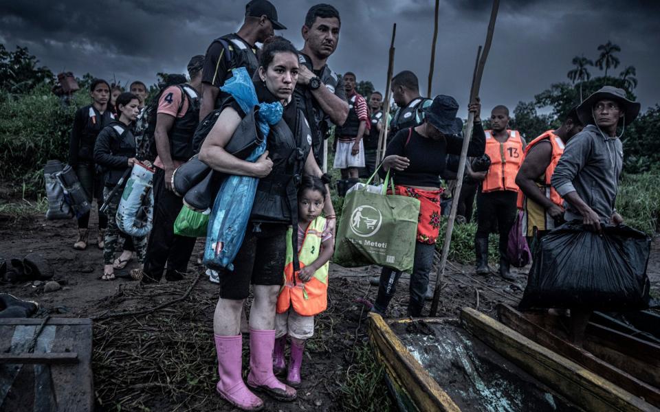 At 5am migrants leave the village of Canaan Mebrillo in the heart of the Darien Gap. They pay $25 per person for each leg of a two-leg journey in dugout canoes. - Simon Townsley