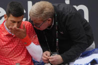Serbia's Novak Djokovic talks to the tournament Doctor Claudio Meli during the quarter final match against Denmark's Holger Rune at the Italian Open tennis tournament, in Rome, Wednesday, May 17, 2023. (AP Photo/Gregorio Borgia)