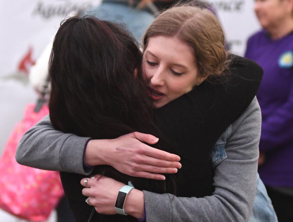 Rachel Knowles gets a hug from Sai El following a ceremony in honor of her Knowles' mother MaryAnn Breault at Holly Tree Racquet Club in Wilmington, N.C., Friday, March 4, 2022. Breault was killed in a domestic violence dispute in front of the club on December 7. El was a friend of Breault and a victim of domestic violence herself.    [MATT BORN/STARNEWS]