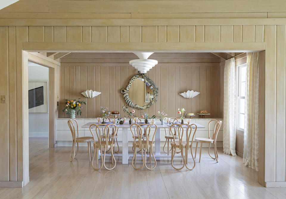 In a Florida beach house, a 1930s French plaster chandelier over the dining table draws the eye up toward the room’s vaulted ceiling