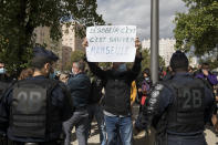 A restaurant owner holds a sign reading "to disobey is to save Marseille" to protest French Health Minister Olivier Veran's visit at La Timone public hospital in Marseille, southern France, Friday Sept. 25, 2020. Angry restaurant and bar owners are demonstrating in Marseille to challenge a French government order to close all public venues as of Saturday to battle resurgent virus infections. The government argues that hospitals in this Mediterranean city are under strain and the closures are the only way to stem the spread while avoiding new lockdowns. (AP Photo/Daniel Cole)