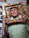 FILE - This Oct. 29, 2009 file photo shows Father Bill Moore with one of his pieces of art in his studio at the Pomona Arts Colony in Pomona, Calif. Father Bill Moore, a Catholic priest and prominent abstract expressionist who spent decades spreading spiritualism through his paintings, has died. He was 71. Longtime friend Tom Irwin says Moore died Sunday, Oct. 18, 2020 of prostate cancer. Seeing his artistic talent, Moore's Southern California parish, the Sacred Hearts of Jesus and Mary, allowed him to spend much of his time painting. (AP Photo/Damian Dovarganes, File)