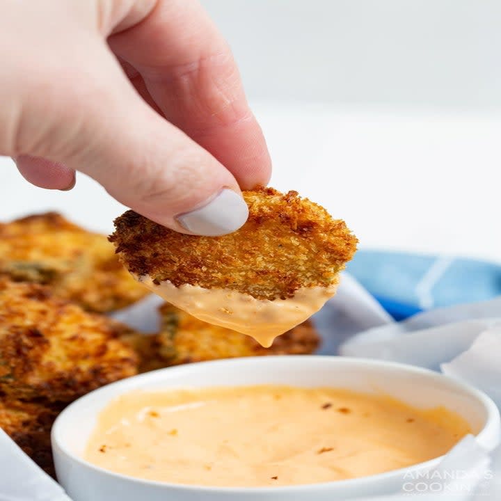 Dipping a fried pickle into sauce.