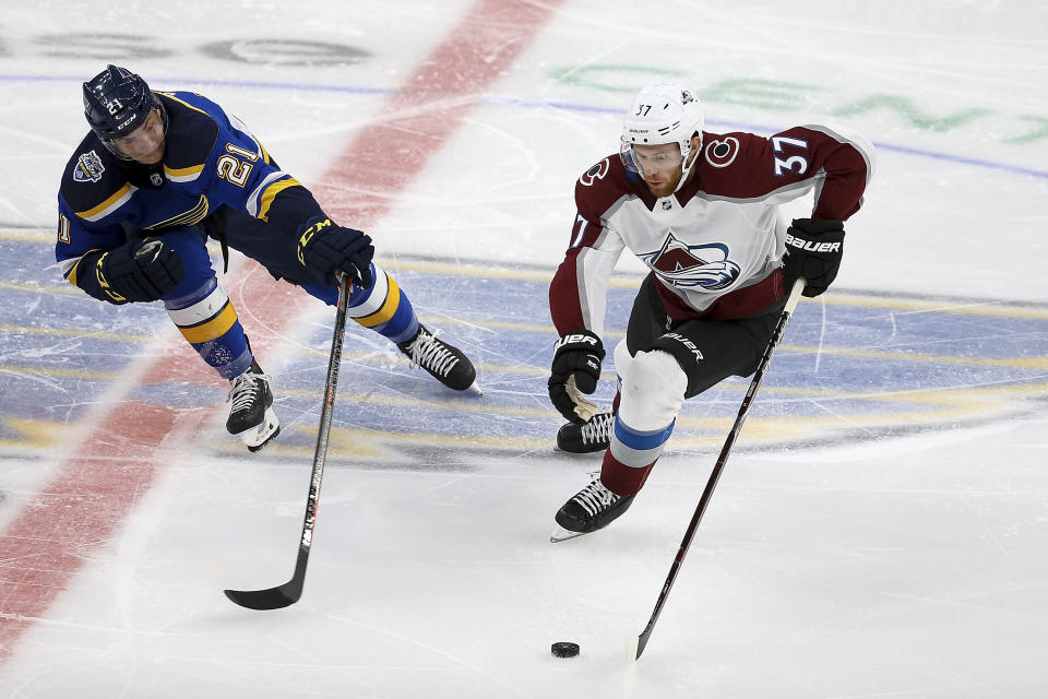 St. Louis Blues' Tyler Bozak (21) and Colorado Avalanche's J.T. Compher (37) vie for control of the puck during the third period of an NHL hockey game Monday, Oct. 21, 2019, in St. Louis. (AP Photo/Scott Kane)
