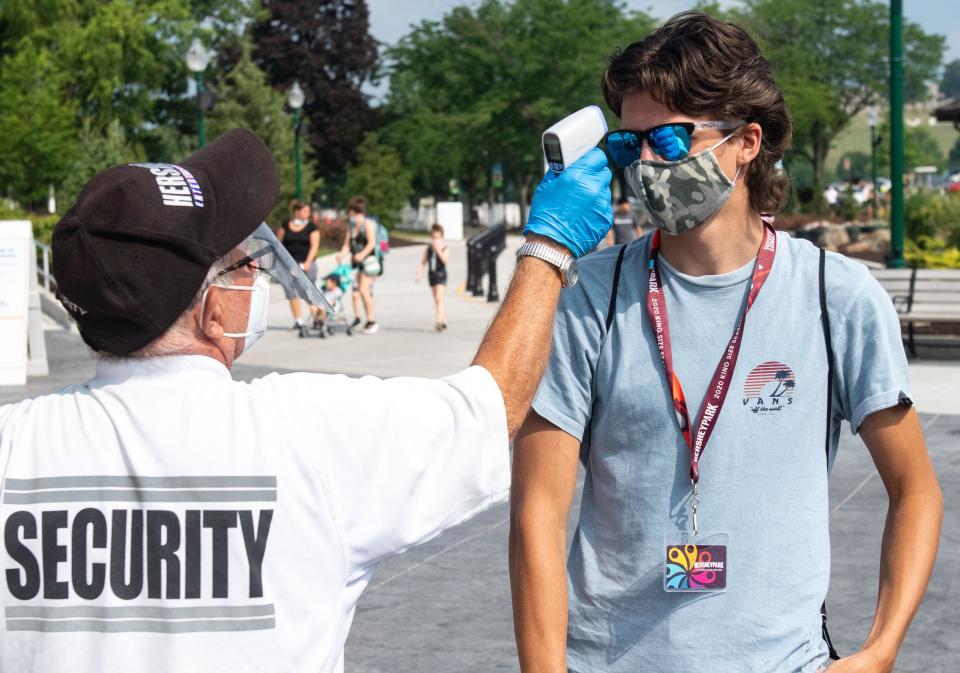 A security person greets visitors with a non-contact temperature reader before entering the park. No one is admitted with aÊtemperature of 100.3 or higher, July 9, 2020.