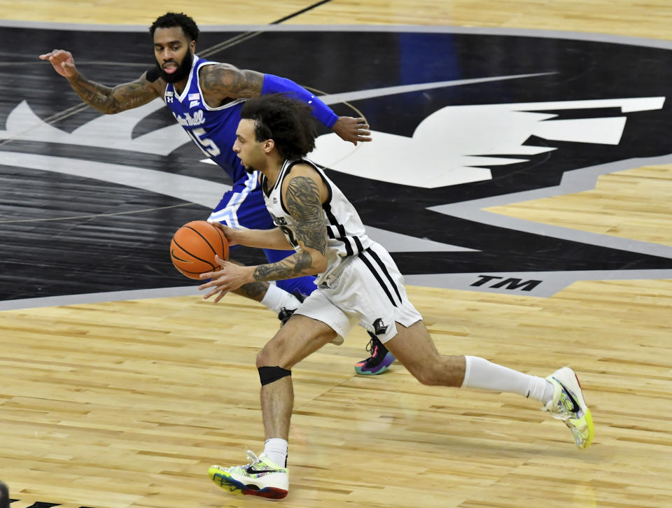 Providence guard Devin Carter (22) drives the ball towards center court as Seton Hall guard Jamir Harris (15) pursues during the first half of an NCAA college basketball game Saturday, March 4, 2023, in Providence, R.I. (AP Photo/Mark Stockwell)