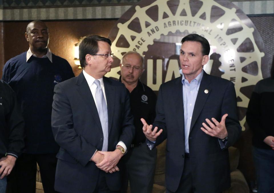 Rep. Gary Peters, D-Mich., left, stands Macomb County Executive Mark Hackel endorses him at the United Auto Workers Local 1264 in Sterling Heights, Mich., Monday, March 3, 2014. Peters planned to put Republican Terri Land on the defensive in their U.S. Senate race by highlighting her 2012 opposition to the federal bailout of General Motors and Chrysler, which is widely credited with saving the U.S. auto industry. (AP Photo/Carlos Osorio)