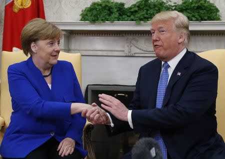 U.S. President Donald Trump welcomes German Chancellor Angela Merkel in the White House Oval Office in Washington, U.S., April 27, 2018. REUTERS/Kevin Lamarque