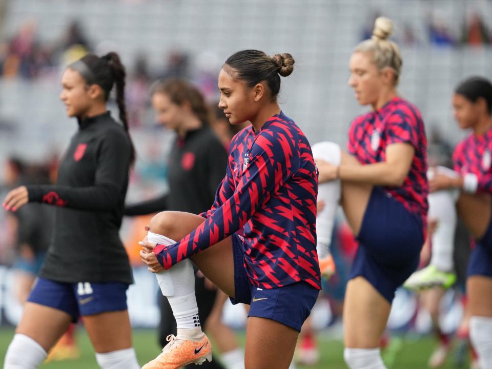 Alyssa Thompson warms up with teammates ahead of a USWNT World Cup match.