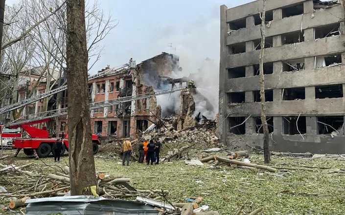 Members of emergency services work at a building destroyed by a Russian attack in Mykolaiv, Ukraine