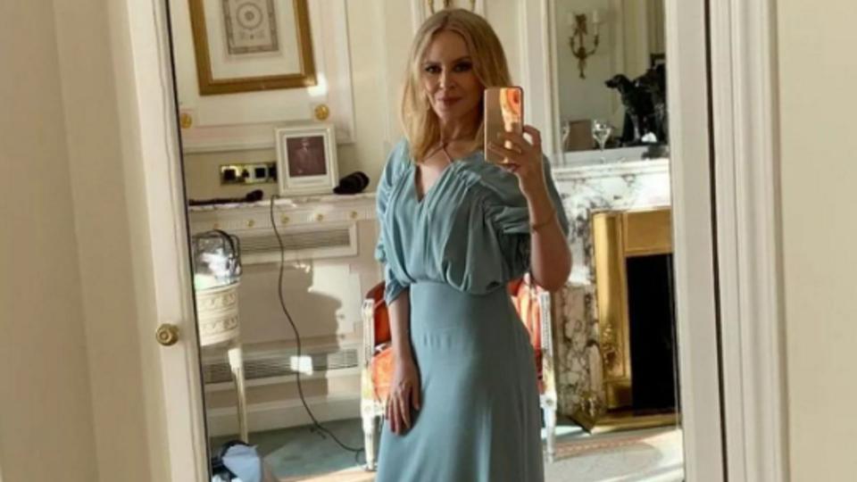 Kylie taking selfie in blue dress in bedroom