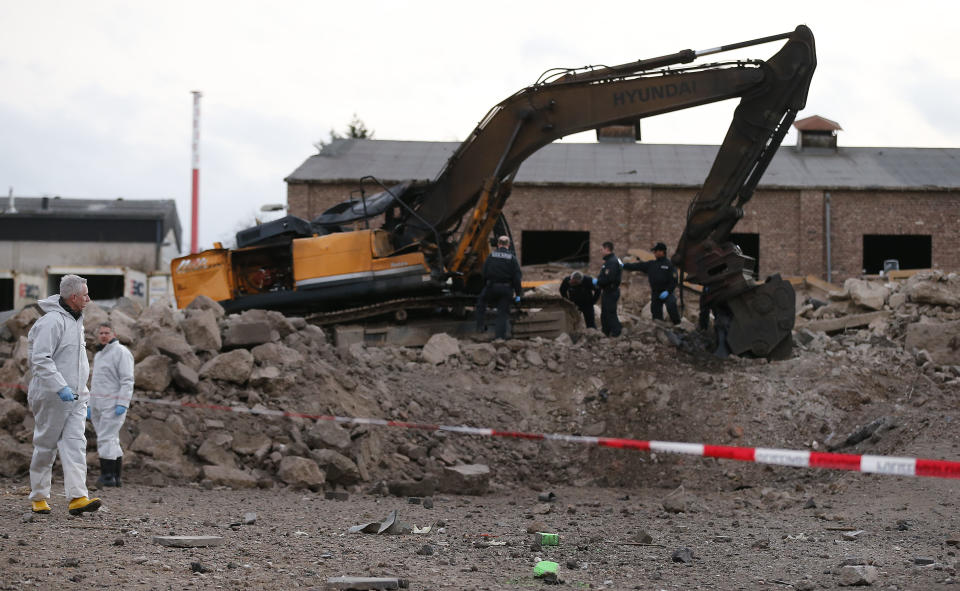 Police forces examine the scene of a World War II bomb explosion during construction works of a digger in Euskirchen, Germany, Friday, Jan. 3, 2014. Police say one person was killed and several others were injured. (AP Photo/Frank Augstein)