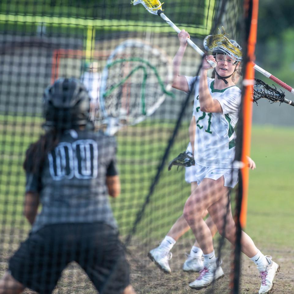 Brinley Christiansen (21) moves on goal to score again to take a 9-0 Crusaders lead during the South Walton vs Catholic girls District 1-1A championship lacrosse game at Pensacola Catholic High School on Thursday, April 13, 2023.