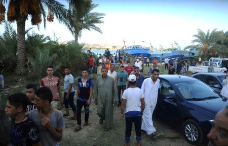 People gather along the shore of the Mediterranean Sea during a search for victims after a migrant boat capsized, in Al-Beheira, Egypt, September 21, 2016. REUTERS/Stringer