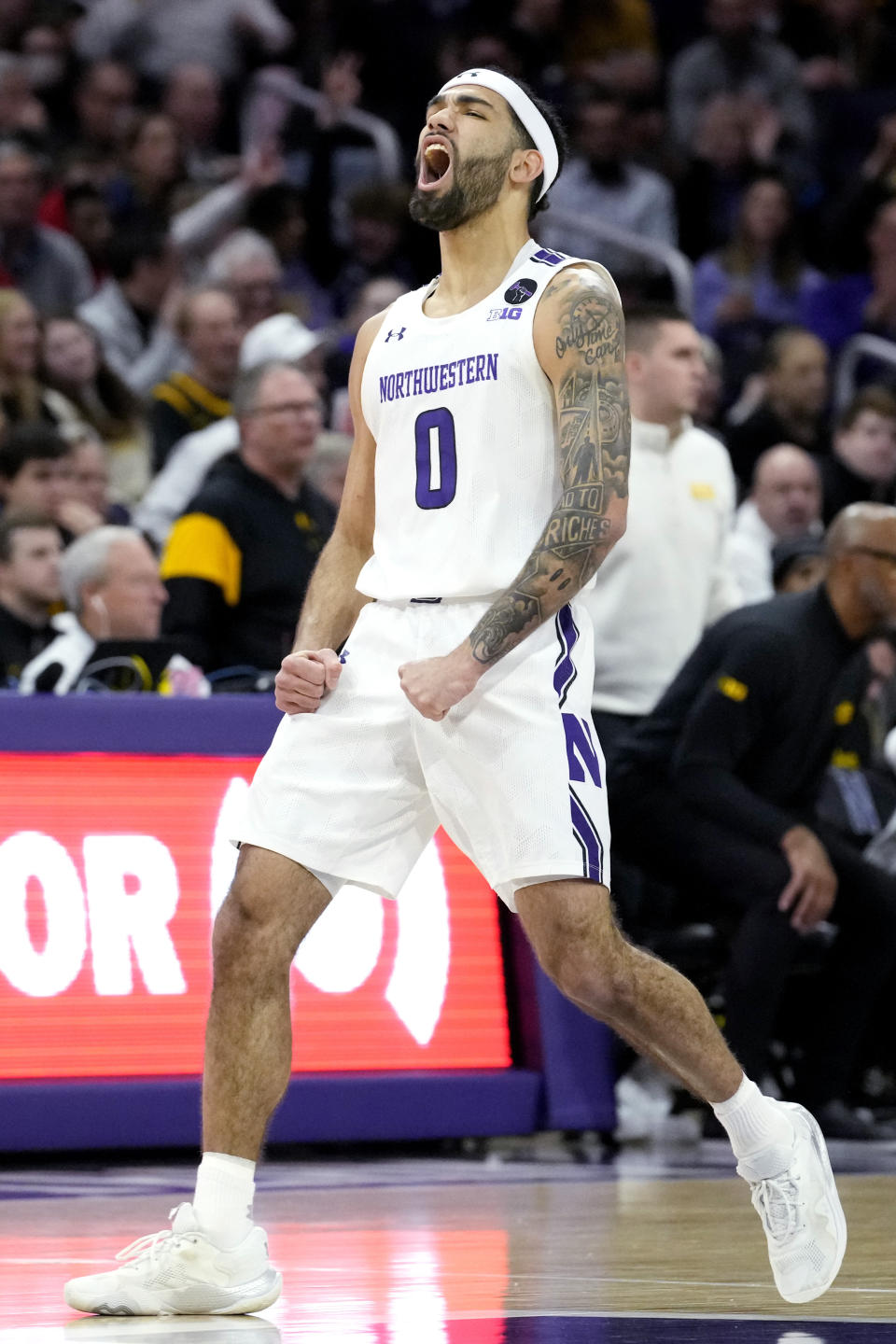 Northwestern guard Boo Buie reacts after a 3-point basket against Iowa during the first half of an NCAA college basketball game in Evanston, Ill., Sunday, Feb. 19, 2023. (AP Photo/Nam Y. Huh)