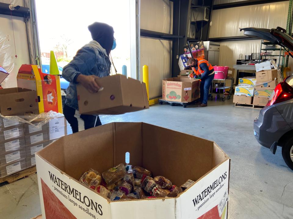 Volunteers at The Foodbank Inc. in Dayton, Ohio, load boxes of food into cars during the twice-weekly drive-thru distribution.