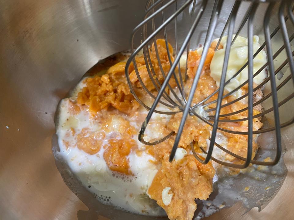 Canned sweet potatoes and other ingredients being mixed together for Trisha Yearwood sweet-potato pie