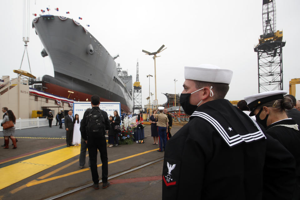 U.S. Navy shipman Aaron Henderson looks over at the USNS Harvey Milk, a fleet replenishment oiler ship named after the first openly gay elected official, prior to the ship's launching in San Diego, Saturday, Nov. 6, 2021. The Navy ship is the second of six vessels in the Navy's John Lewis-class program, second to the USNS John Lewis. (AP Photo/Alex Gallardo)