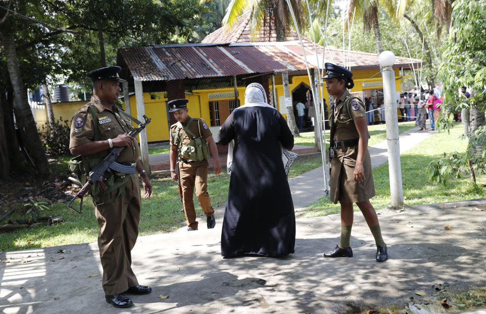 Sri Lankan police officers stand guard at a polling station as people queue to cast their votes during the presidential election in Colombo, Sri Lanka, Saturday, Nov. 16, 2019. (Polls opened in Sri Lanka’s presidential election Saturday after weeks of campaigning that largely focused on national security and religious extremism in the backdrop of the deadly Islamic State-inspired suicide bomb attacks on Easter Sunday. (AP Photo/Eranga Jayawardena)