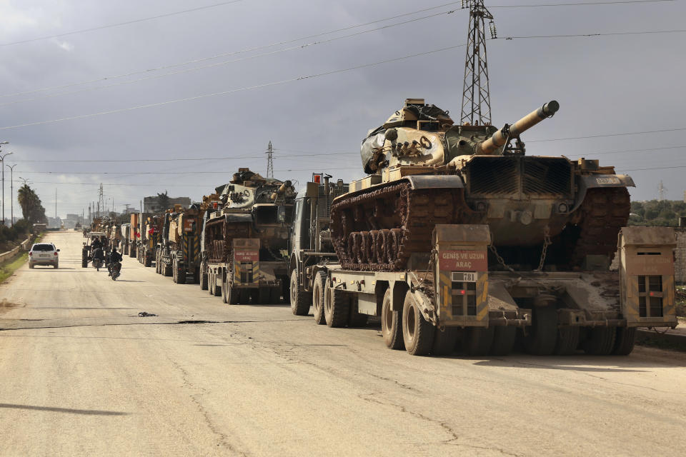 Turkish military convoy drives through the village of Binnish, in Idlib province, Syria, Saturday, Feb. 8, 2020. Several Turkish armored vehicles and tanks entered rebel-controlled northwestern Syria since Friday, the latest reinforcements sent in by Ankara amid a Syrian government offensive that this week brought the two countries' troops into a rare direct confrontation. (AP Photo/Ghaith Alsayed)