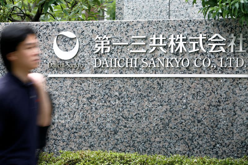 FILE PHOTO: Man walks past a sign of Daiichi Sankyo Co., Ltd. at the company's head office in Tokyo