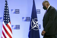 United State Secretary of Defense Lloyd Austin steps onto the podium during arrival prior to a meeting at NATO headquarters in Brussels, Wednesday, April 14, 2021. (Kenzo Tribouillard, Pool via AP)