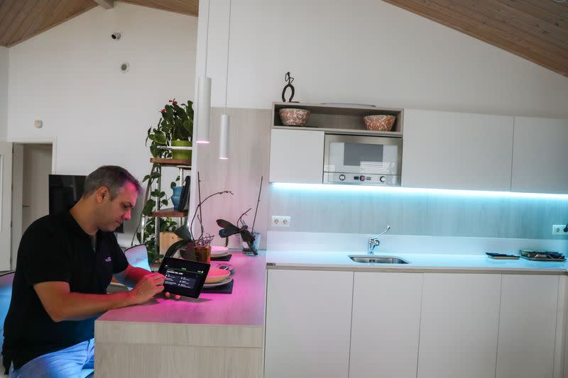 Echevarria, founder of the building company specialised in all-wood, low-emission homes 100x100 Madera, checks the air quality in his house, in Guadalix de la Sierra