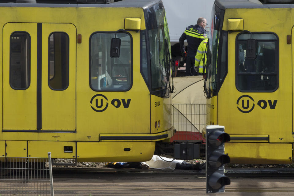 A body is covered with a white sheet after a shooting in a tram in Utrecht, Netherlands, Monday, March 18, 2019. Police in the central Dutch city of Utrecht say on Twitter that "multiple" people have been injured as a result of a shooting in a tram in a residential neighborhood. (AP Photo/Peter Dejong)