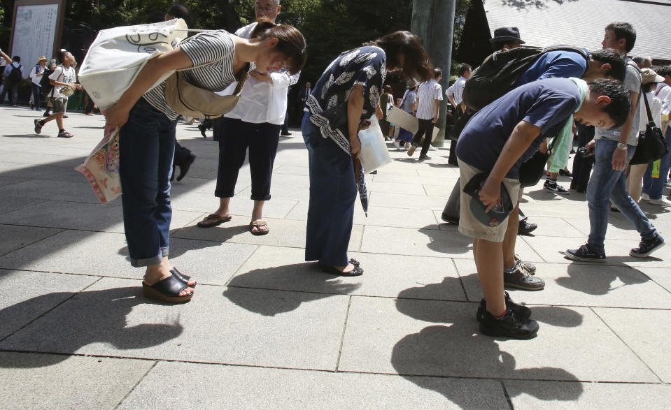 Visitors bow before entering the main gate at Yasukuni Shrine in Tokyo, Wednesday, Aug. 15, 2018. Japan marked the 73rd anniversary of the end of World War II. (AP Photo/Koji Sasahara)