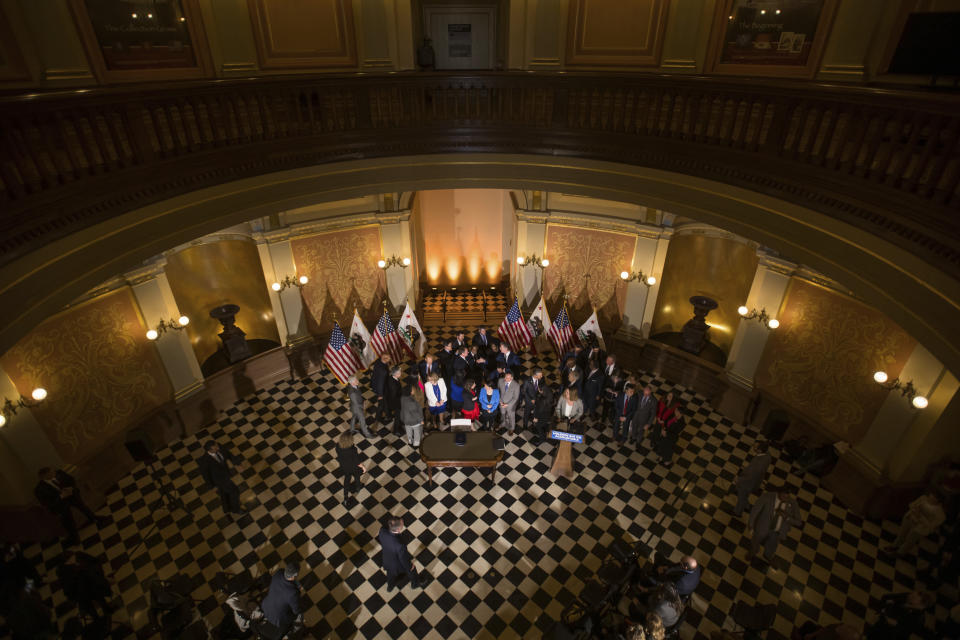 Gov. Gavin Newsom shakes hands with legislators and state officials in the Capitol rotunda in Sacramento before signing a bill aimed at addressing gas price gouging, Tuesday, March 28, 2023, in Sacramento, Calif. (Xavier Mascareñas/The Sacramento Bee via AP)