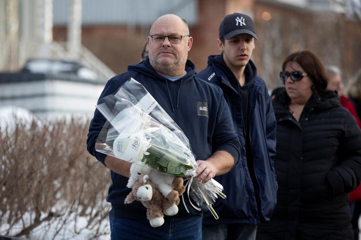 A member of the public brings tributes to the Garderie Educative Sainte-Rose in Laval, Quebec, February 2023 (Evan Buhler/REUTERS)