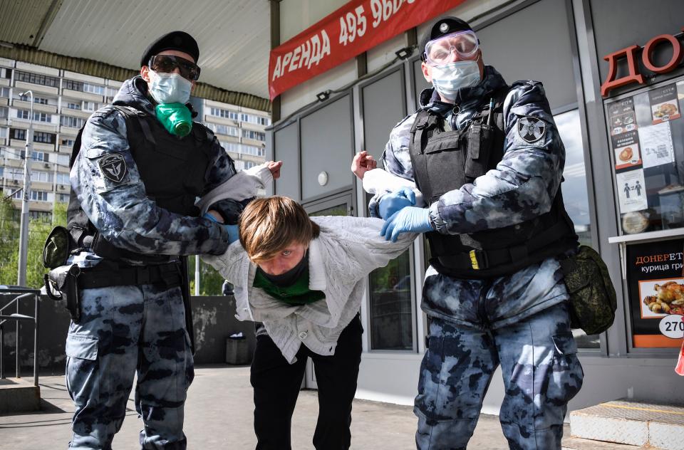 A man is detained in Moscow outside a shop for disobeying orders amid the coronavirus pandemic. Source: Getty