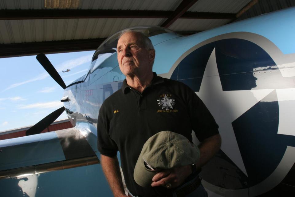 Bill Anders is standing next to an airplane.