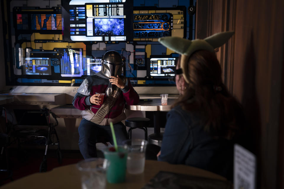 Two fans chat while celebrating the Star Wars Day at Scum and Villainy Cantina, a bar located on Hollywood Blvd, in Los Angeles, Tuesday, May 4, 2021. California has the lowest infection rate in the country. Los Angeles County, which is home to a quarter of the state's nearly 40 million people and has endured a disproportionate number of the state's 60,000 deaths, didn't record a single COVID-19 death Sunday or Monday, which was likely due to incomplete weekend reporting but still noteworthy. (AP Photo/Jae C. Hong)