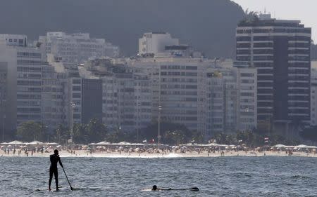 A man paddles on a stand up board on Copacabana beach in Rio de Janeiro, Brazil, July 30, 2015. REUTERS/Sergio Moraes