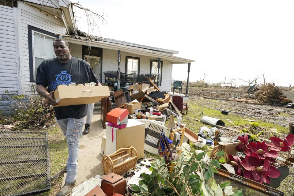 Sammie Watkins, a son-in-law of longtime Silver City, Miss., resident Mary Kitchen, carries out salvageable items as the family clears out the tornado damaged wood frame house, Tuesday, March 28, 2023. The home, like many hit by Friday's tornado in the Mississippi Delta, sustained severe damage. (AP Photo/Rogelio V. Solis)